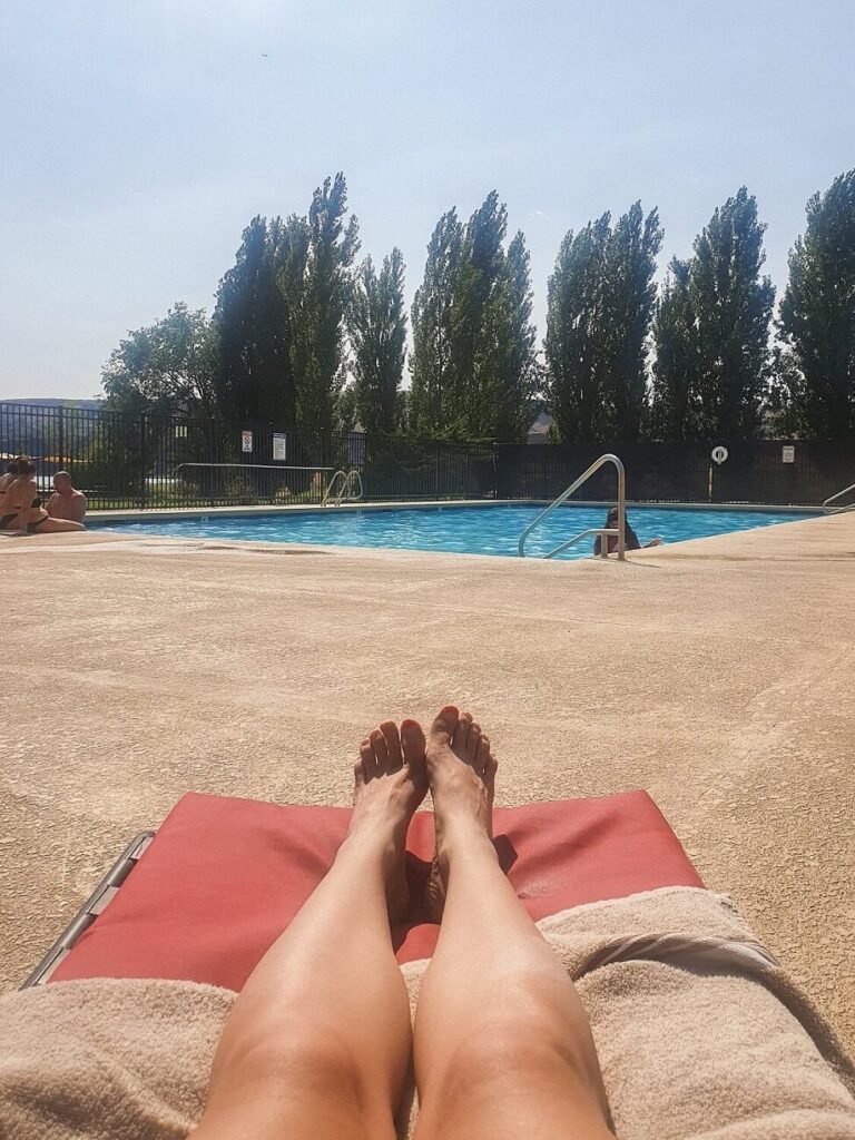 A woman sunbaking on a pool chair at Smokiam RV Resort and Campground near Soap Lake.