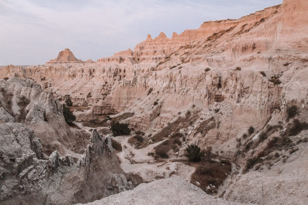 Hiking along a rocky ledge on the Notch Trail at Badlands National Park.