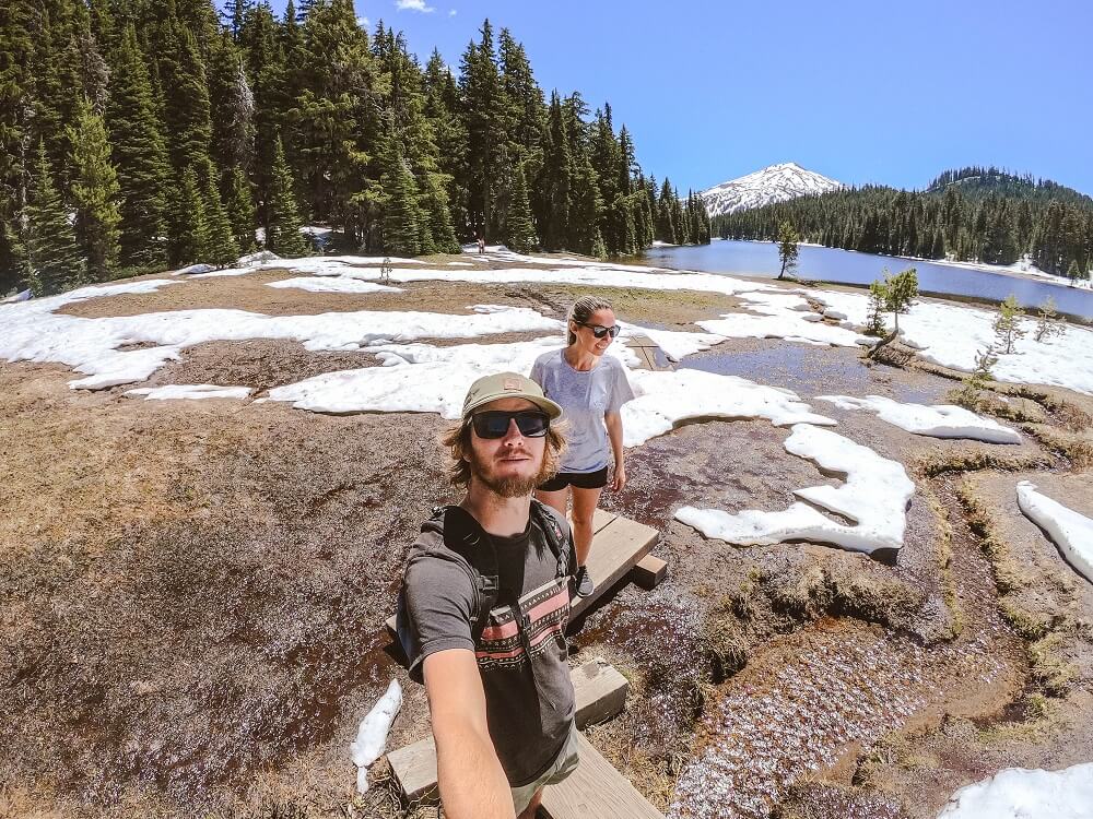Two people hiking around Todd Lake in Central Oregon, with Mt Hood in the background.