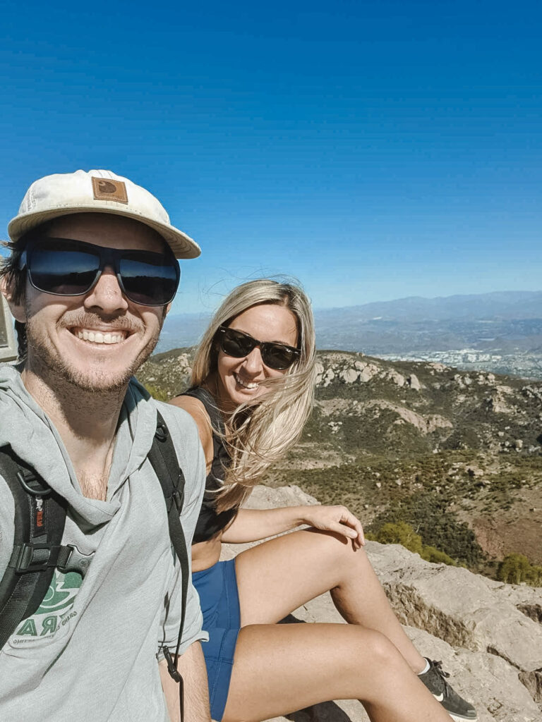 Hikers sitting at the top of Sandstone Peak in the Santa Monica Mountains, California.